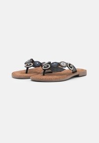 Zwarte flip-flops met een bewerkte band die cirkelpatronen in blauw, zilver en zwart bevat op een bruine nep-suède voetbed. Platte zool.