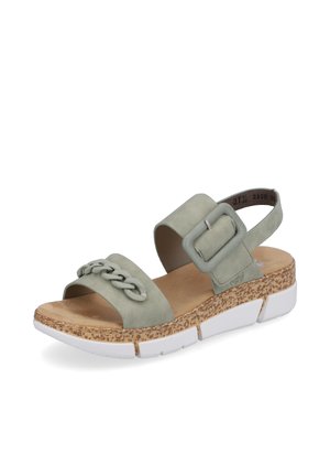 Sandales en suède vert avec une sangle tressée, une grande boucle et une semelle en liège texturée, dotées d'une base de plateforme blanche.