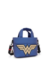 Sininen käsilaukku, jossa on vaaleanruskea Wonder Woman -logo, pehmustetut kahvat ja irrotettava musta olkahihna punaisella korostuksella sekä pieni ripustin.