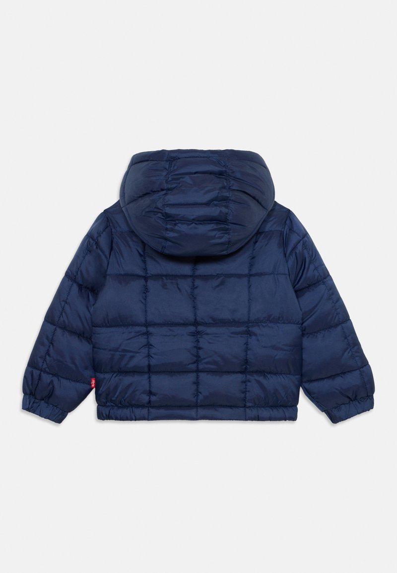 Chaqueta acolchada de color azul marino con capucha. Presenta un diseño acolchado, puños elásticos y un pequeño detalle de logo en la manga izquierda.