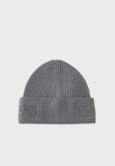 Bonnet gris en maille côtelée avec revers plié présentant un texte partiel embossé sur un fond blanc uni.