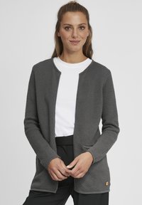 Gray textured cardigan with a rounded neckline, open front, side pockets, and a wooden accent near the hem, worn over a white t-shirt.