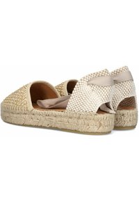 Beige woven espadrilles featuring a textured upper, jute sole, and elastic accents on the back for secure fit. Flat sole with rounded design.