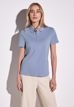 Lichtblauw polo shirt van zachte stof, met een kraag, drie knopen en korte mouwen. Gladde textuur, eenvoudig ontwerp.