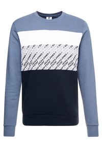 Mikina s bloky barev v odstínech světle modré, bílé a tmavě modré. Grafický text na hrudi. Vyrobena z měkké látky.