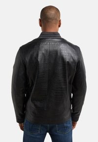 Veste en cuir noir avec un motif crocodile texturé, détail de col brodé et l'étiquette "CARLO COLUCCI" au dos.