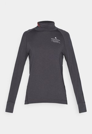 Tmavě šedá dlouhá rukávová košile s vysokým límcem, bočními rozparky a kontrastním vnitřním límcem. Obsahuje potisk na hrudi a elastický materiál.