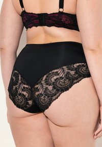 Zwarte kanten slip met een bloemenpatroon langs de zijkanten, voorzien van een soepele tailleband en een zachte stoftextuur. Achteraanzicht weergegeven.