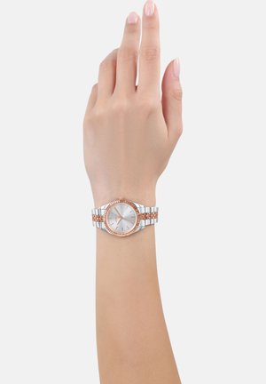 Silberner und roségoldener Armbanduhr mit rundem Ziffernblatt, Metallarmband mit wechselnden Gliedern und minimalistischen Stundenmarkierungen.