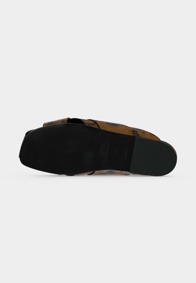 Chaussure plate en cuir avec motif peau de serpent vue de la semelle, montrant une semelle extérieure noire et un bout arrondi sur fond blanc.
