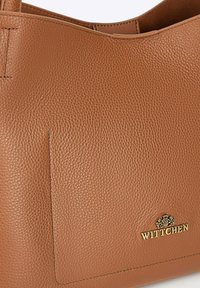 Bruine leren handtas met een gestructureerd oppervlak, subtiele stiksels en een gouden logo-accent. Ontwerp met open bovenkant en een zijvak.