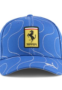 Blå kasket lavet af stof med virvlende hvide linjer. Har et sort-kantet gult Ferrari-logo på fronten og et Puma-logo på siden.