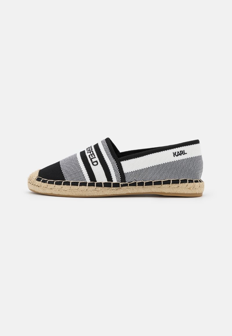 Espadrille slip-on rayée noir et blanc avec semelle en jute tressée et texte « KARL LAGERFELD » sur les côtés supérieurs.