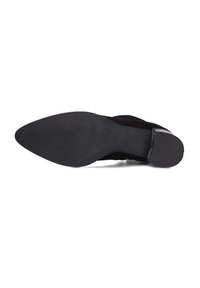 Zwarte suède schoenen met een spitse neus en een slanke hak. De zool is van gestructureerd rubber voor grip en heeft een minimalistisch ontwerp.