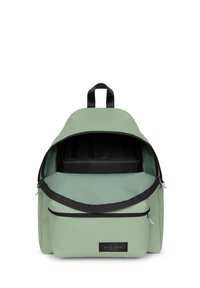 Mochila de tela verde con un zipper negro, que cuenta con un amplio compartimento principal y un bolsillo frontal. La etiqueta en la parte delantera muestra el nombre de la marca.