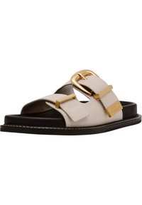 Beige leren sandaal met een brede band, gouden gespaccent en een zwartezool. Heeft stikdetails en een open teenontwerp.