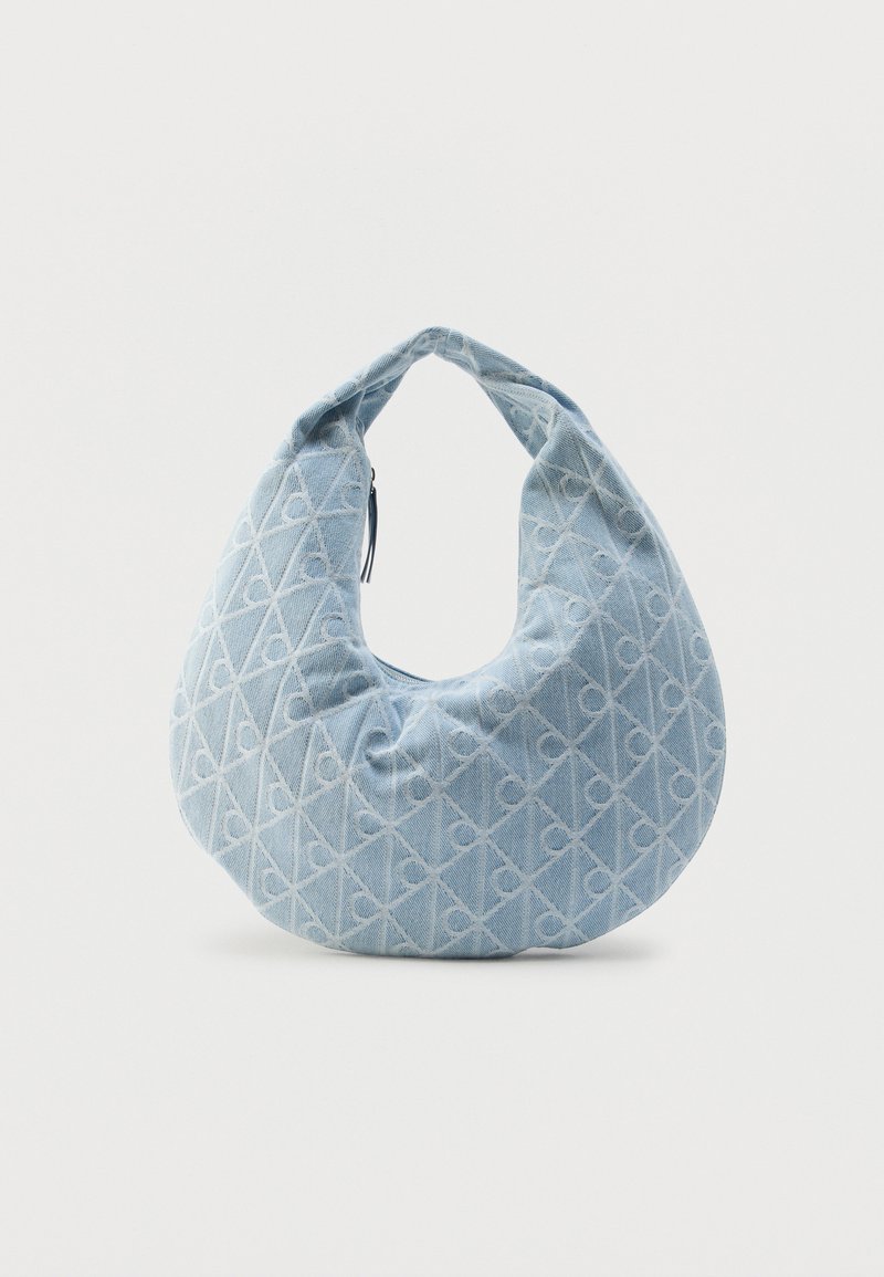 Μπλε υφασμάτινη τσάντα ώμου με στρογγυλεμένο σχήμα, υφή με μοτίβα και επάνω χερούλι. Κλείνει με φερμουάρ και έχει το ίδιοχρωμο λογότυπο σε όλη την επιφάνεια.