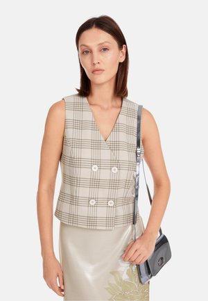Beige karierte ärmellose Bluse mit V-Ausschnitt, doppelter Knopfleiste, glattem Stoff und kombiniert mit einem glänzenden silbernen Bleistiftrock und einer Handtasche.