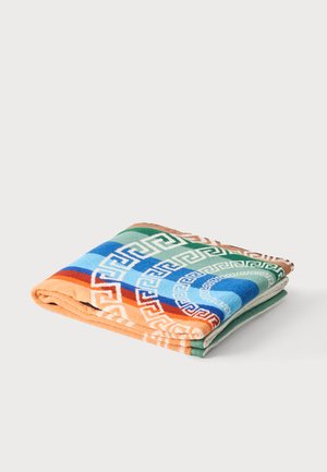 Gefaltetes buntes Handtuch mit geometrischen griechischen Schlüsselmuster in Orange, Blau, Grün und Weiß auf weißem Hintergrund.
