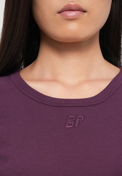 Purple ribbed top featuring a round neckline and an embroidered "EP" logo near the collar. Smooth fabric and close-fitting design.