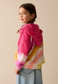 Felpa con cappuccio tie-dye con colori vivaci rosa, arancione e giallo. Ha una texture morbida, una tasca a marsupio e polsini a costine.