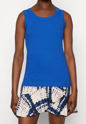 Blauwe gestreepte mouwloze top gecombineerd met een geprinte crèmekleurige en marineblauwe gerimpelde rok. Heeft een ronde halslijn en een aansluitend ontwerp.