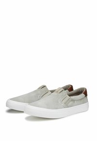 Scarpe slip-on grigie in tela con una superficie liscia, suole in gomma bianca e dettagli in pelle marrone sul tallone.