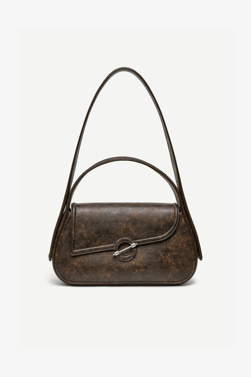 Sac à main en cuir brun foncé texturé avec deux anses, forme rectangulaire arrondie, et fermeture à bouton circulaire argenté sur le rabat avant.