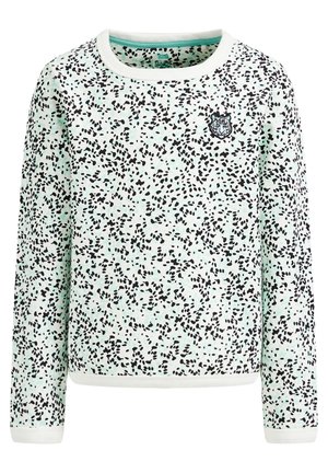 Chemise blanche à manches longues avec motif de points noirs irréguliers et petite tête de tigre brodée sur la poitrine gauche, col et poignets côtelés.