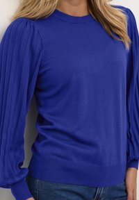 Królewsko niebieski sweter typu pulower z rękawami o prążkowanej fakturze oraz klasycznym okrągłym dekoltem. Miękka dzianina i dopasowane wykończenie u dołu.