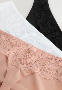 Drie lingerie-items: perzik met kantafwerking, wit met bloemmotief-kant, en zwart met gestructureerd kant aan de bovenkant. Gladde stof met complexe details.