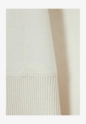 Light cream sweater featuring a smooth, soft texture with ribbed hem and seam detailing. Composed of a lightweight, breathable fabric.