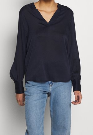 Navy blue blouse with a V-neck, long balloon sleeves, and a relaxed fit. Soft, smooth fabric with subtle texture and a straight hem.