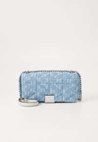 Μπλε τζιν καπιτονέ τσάντα χιαστί με λαμπερή ασημένια αλυσίδα και λευκή δερμάτινη λεπτομέρεια. Διαθέτει μεταλλική πλάκα με λογότυπο μπροστά.