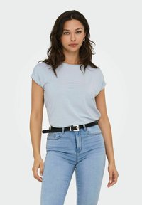 Camiseta de manga corta en azul claro con cuello redondo, de tela texturizada, combinada con unos pantalones vaqueros azules de cintura alta y un cinturón negro con hebilla plateada.