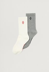 To sæt ribbede sokker: et hvidt med et rødt logo, og et gråt med et sort logo. Begge er halvlange og lavet af blødt stof.