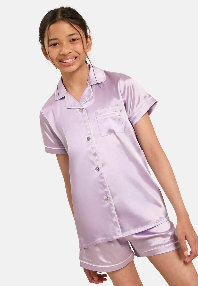 Set di pigiami in satin lilla composto da una camicia a maniche corte con bottoni e taschino, abbinato a pantaloni corti, entrambi con rifiniture bianche a contrasto.