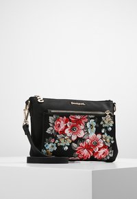 Czarna torebka na ramię z kwiatową haftem w odcieniach czerwieni, różu i niebieskiego. Posiada kieszeń na zamek oraz regulowany pasek.