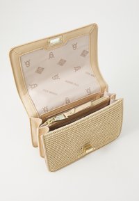 Portafoglio beige con texture intrecciata e dettagli dorati, dotato di un compartimento interno e tasca con zip, foderato in tessuto chiaro con motivo del logo.