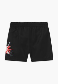 Pantalones cortos deportivos negros con cintura elástica, que presentan un logotipo gráfico en blanco y rojo en el lado izquierdo. Tela sintética suave.