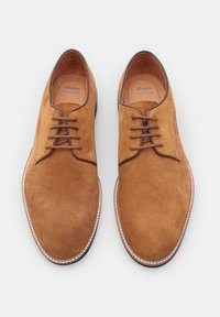 Scarpe lacci in suede marrone con una finitura liscia, punta arrotondata, cuciture in contrasto e soletta imbottita. Presentano un design classico.
