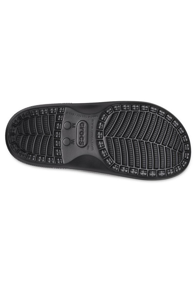 Suela de zapato de goma negra con patrones de tracción texturizados y agujeros de drenaje; etiquetada con indicadores de tamaño "M" y "W."