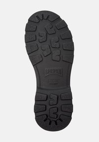Suola di scarpa in gomma nera con motivi di battistrada unici e il logo "Camper Bridge Xtra Grip" al centro. Indicazione della taglia 38.