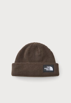 Bonnet en tricot côtelé marron avec revers plié et étiquette noire affichant le logo The North Face en blanc.