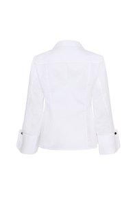 Balta kokvilnas krekls ar strukturētu dizainu, izmantojot klasisku apkakli un garām piedurknēm. Ievērojami melni pogas uz aprocēm.