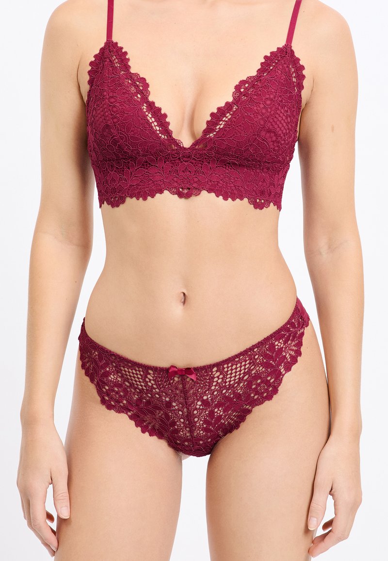 Weinrote Spitzen-Bralette mit gezackten Kanten und verstellbaren Trägern, kombiniert mit passenden Spitzenunterhosen mit Blumenmustern und einer Schleifenapplikation.