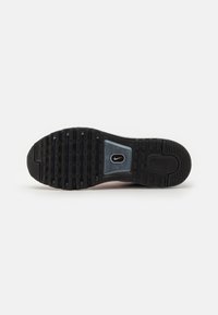 Suela de zapato de goma negra con un patrón de relieve prominente, acento azul transparente y logotipo de marca. Textura suave y duradera con bordes reforzados.