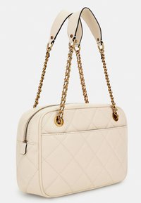 Valkoinen tilkkupussi, jossa on suorakulmainen muoto, kultaketju ja nahkahihnat, vetoketjusuljenta sekä kullanväriset yksityiskohdat.