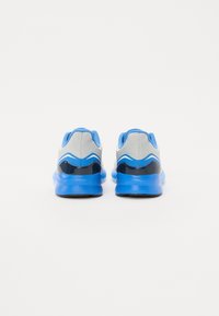 Des chaussures de sport bleues et grises avec un dessus en maillage texturé, des accents synthétiques lisses et une semelle sombre contrastante.