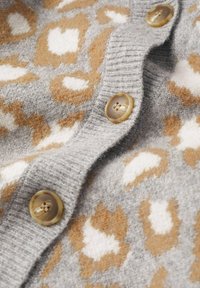 Cardigan lavorato a maglia grigio con un motivo a stampa leopardata in beige e bianco. Presenta grandi bottoni rotondi marroni lungo l'apertura frontale.